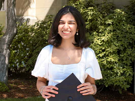 Rea Pittie holding graduation cap