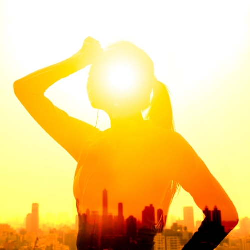 Woman in a hazy heat wave in an urban area