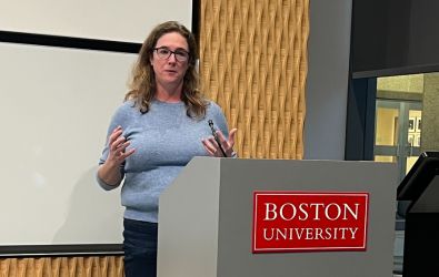 Emily Ryan lectures at a podium.