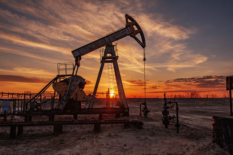 Oil rig machine at sunset.