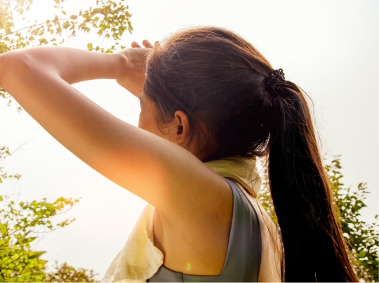 Person looking toward the sky on a hot day.