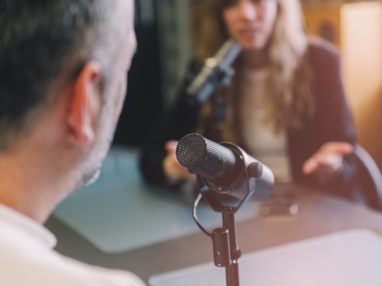 Close-up of person speaking into a microphone.