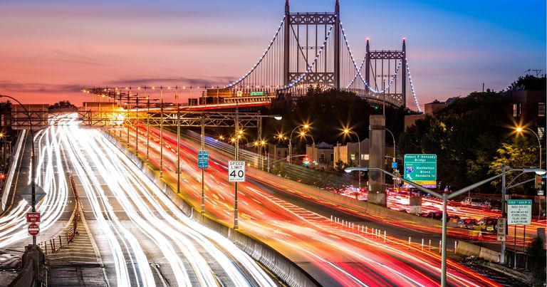 Traffic zooms by a bridge.