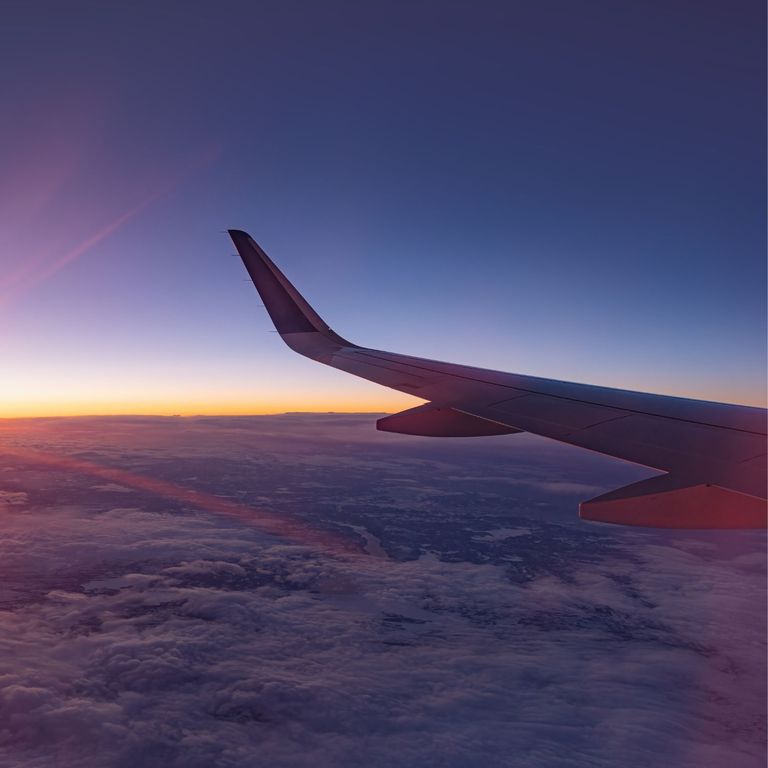A plane flies during sunset