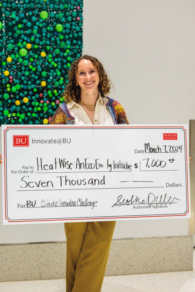 Woman student founder smiling with a prize money check