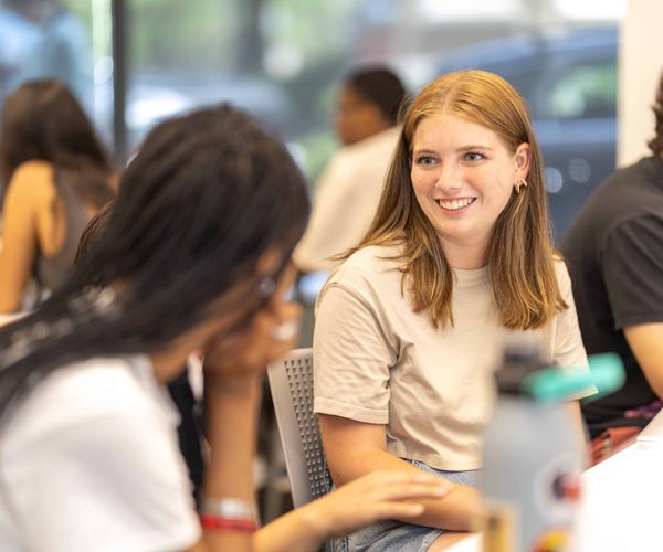 Woman smiling and listening to a student talk