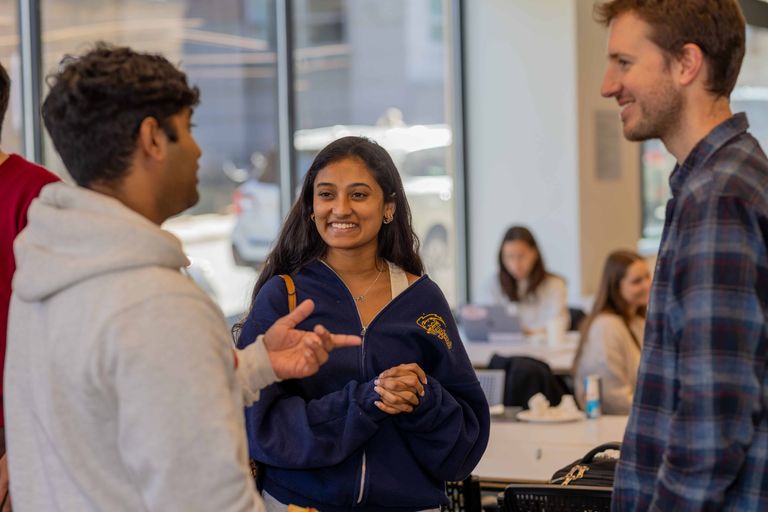 Woman smiling in conversation with other students