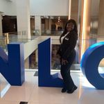 Gloria Ampadu-Darko posing in front of NLC signs