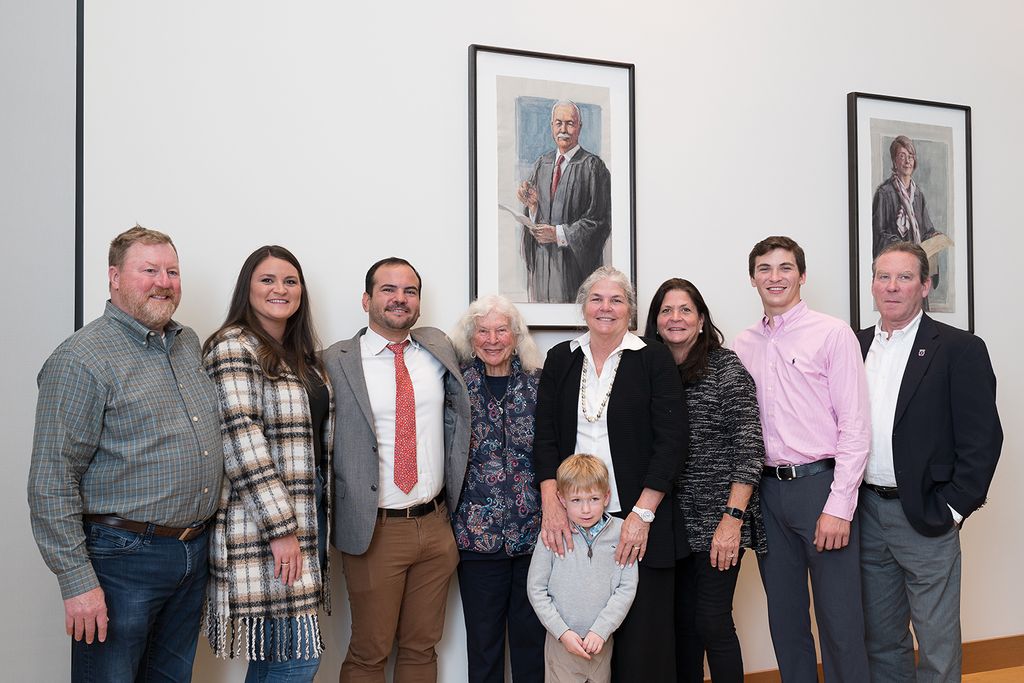 Judge Juan Torruella's family in front of his portrait in Barristers Hall