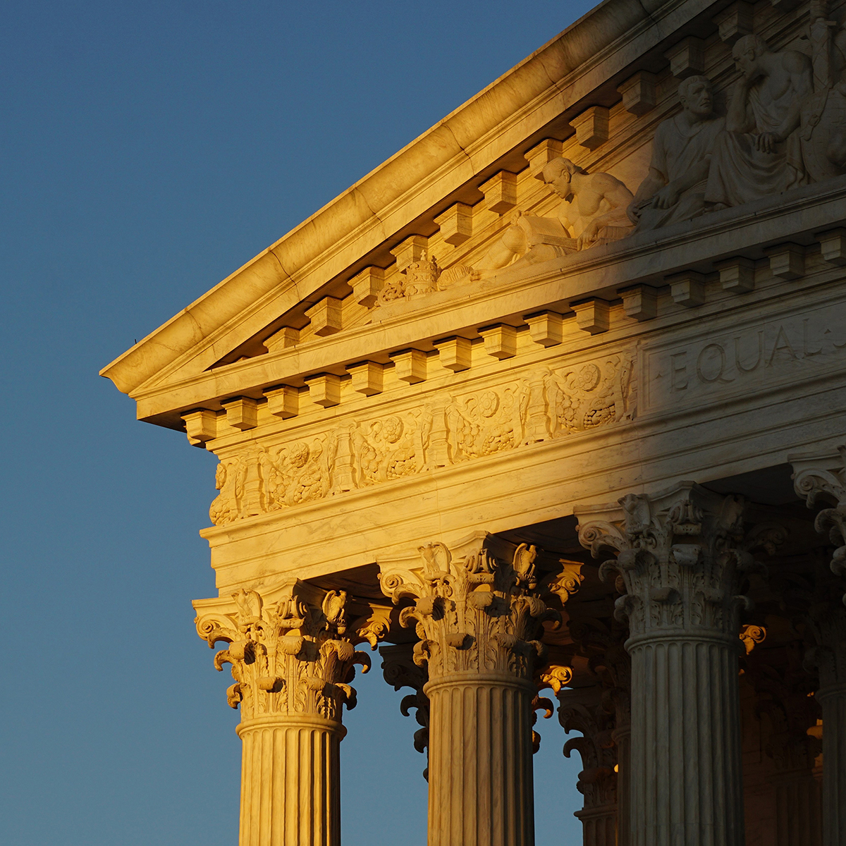 The facade of the US Supreme Court building half obscured by shadow