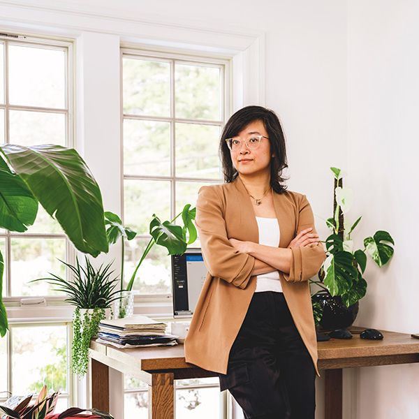 Ming Zeng (LAW'09) stands in front of her desk.
