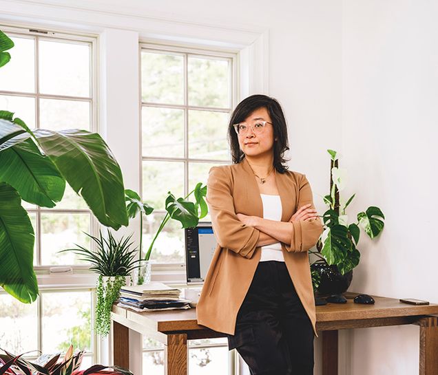 Ming Zeng (LAW'09) stands in front of her desk.