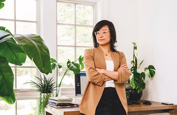 Ming Zeng (LAW'09) stands in front of her desk.