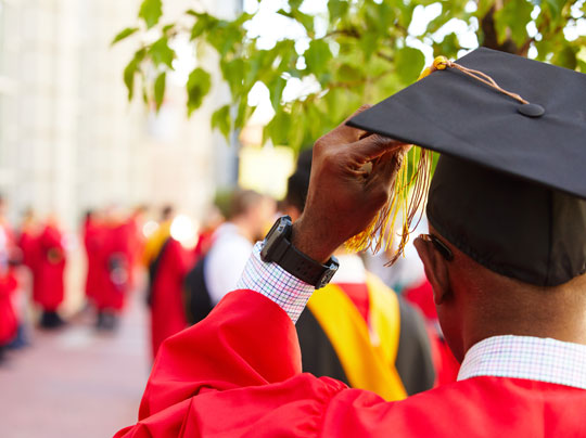 Graduation Information - image shows a student looking down Commonwealth Avenue awaiting the commencement ceremony.