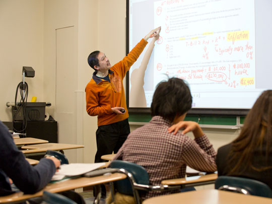 BU MET business students reviewing graphs and charts in a classroom at Boston University.