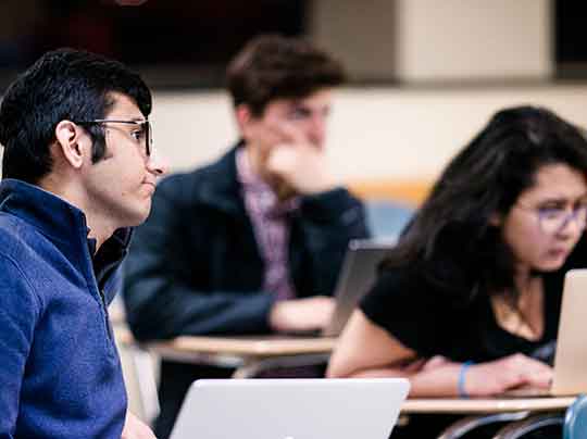 Health Communication students working with laptops in a classroom at Boston University's Metropolitan College.