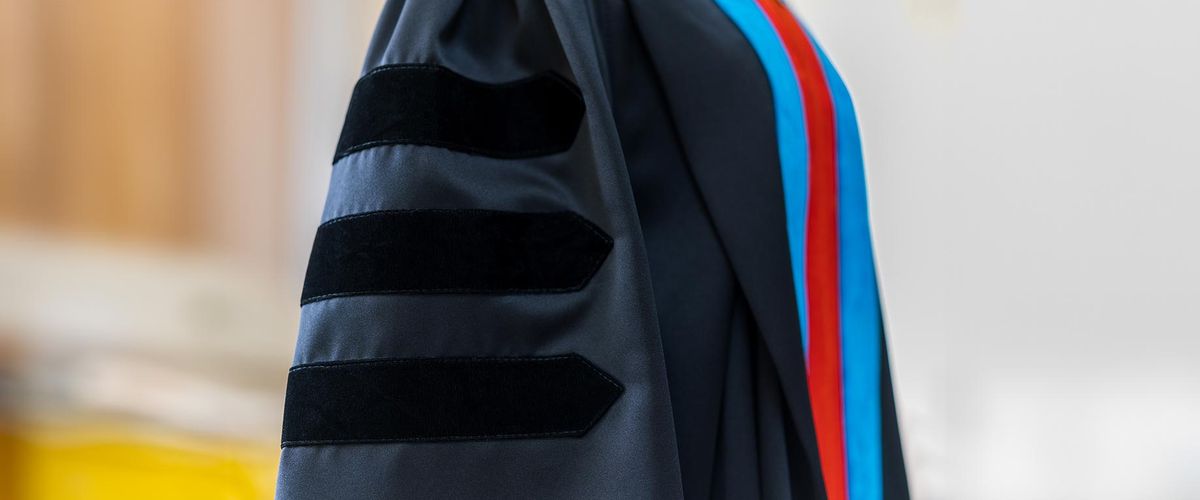 A closeup photo of a graduate wearing PhD regalia