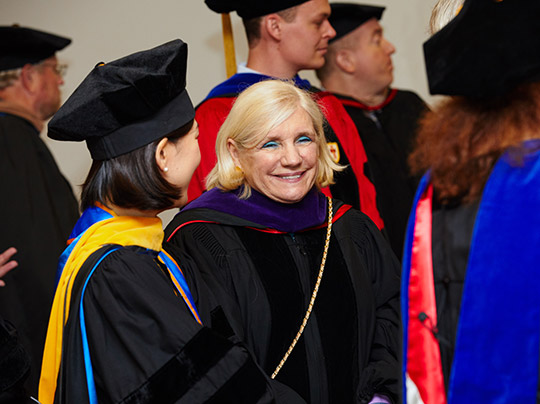 Virginia Greiman (SED’70, LAW’03) socializes with MET faculty members during a commencement ceremony