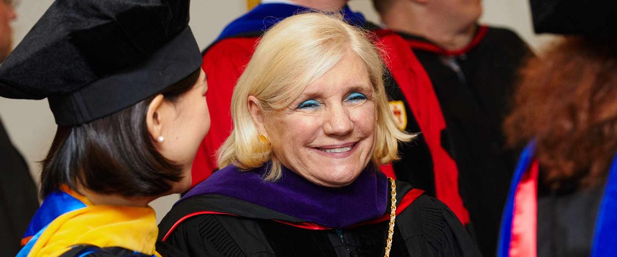 Virginia Greiman (SED’70, LAW’03) socializes with MET faculty members during a commencement ceremony