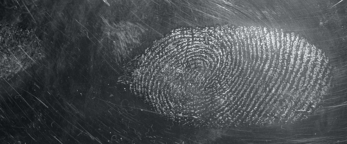 Grey fingerprint on black surface