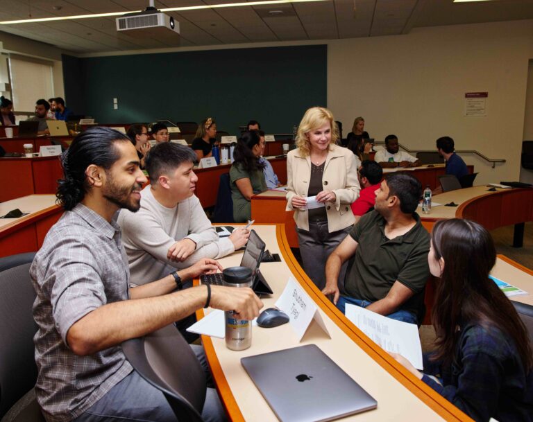 Professor in discussion with a few students during class