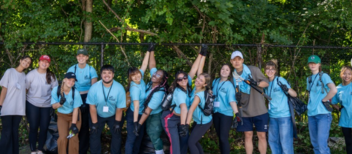 a group of volunteer students all dressed in light blue pose for a group photo