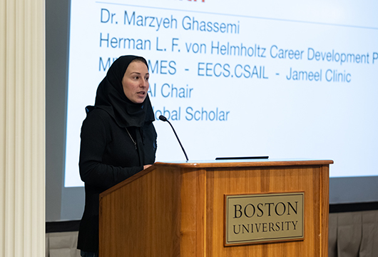 Professor standing at podium at front of classroom