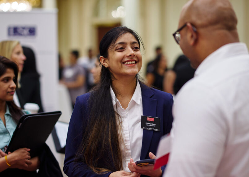 MBA student speaking with an employer at a networking fair