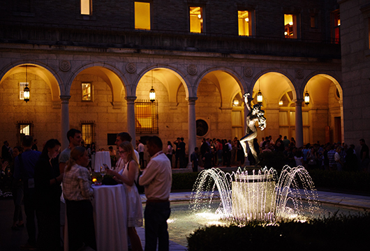 Group of people gathered around a table in a courtyard at night