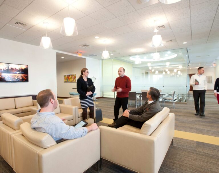 Professionals having a discussion in a lobby space.