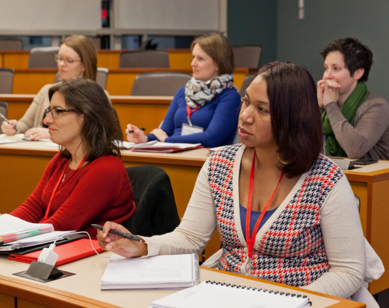 Executive education students seated in a classroom listening intently