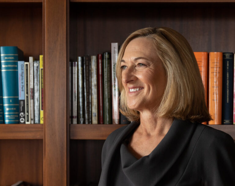 Dean Susan Fournier standing in front of bookshelf