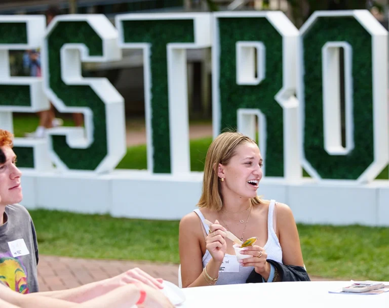 Undergrad Student sit outside at a table at chat