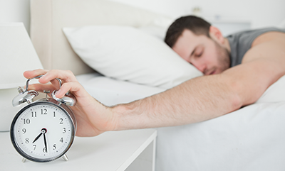 man-in-bed-hitting-alarm