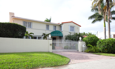 Luxury home with gate and palm trees