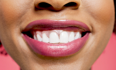 Close-up detail of an African American woman grinning.