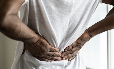 Close up on back and hands of man suffering back pain