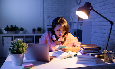 College student studying in a dark room.