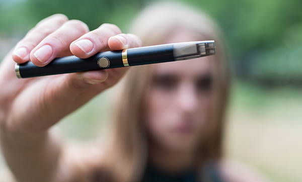 Woman smoking electronic cigarette outdoor