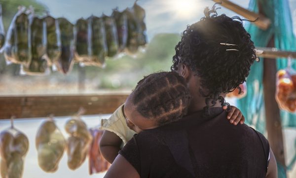 woman holding infant outdoors in africa