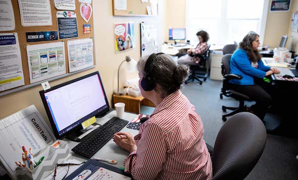 988 line operators sit at desks fielding calls