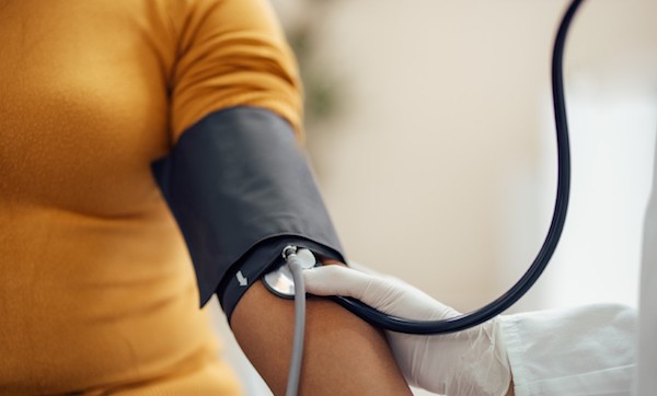 Doctor takes patient's blood pressure with cuff