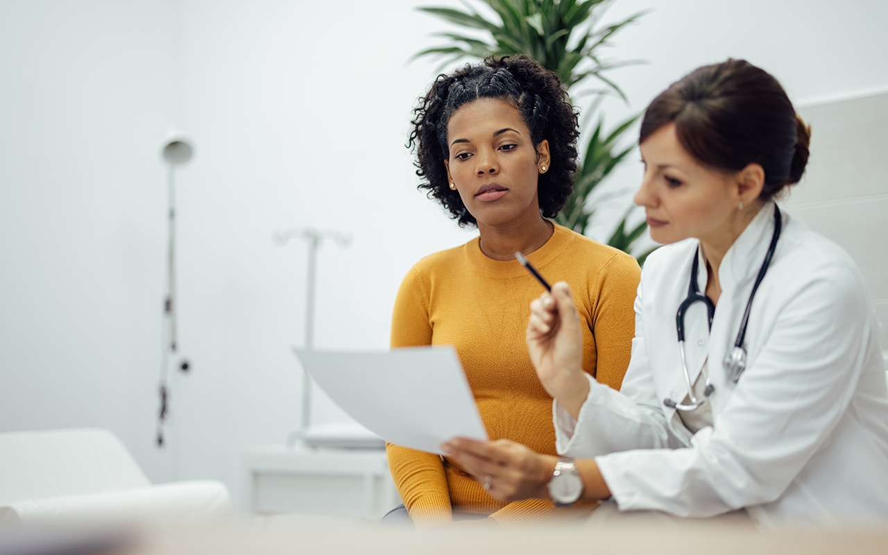 Doctor reads off a paper to woman patient