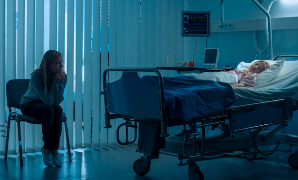 Sick Little Girl Lying in the Hospital Bed Sleeping, Her Mother Worries Beside Her