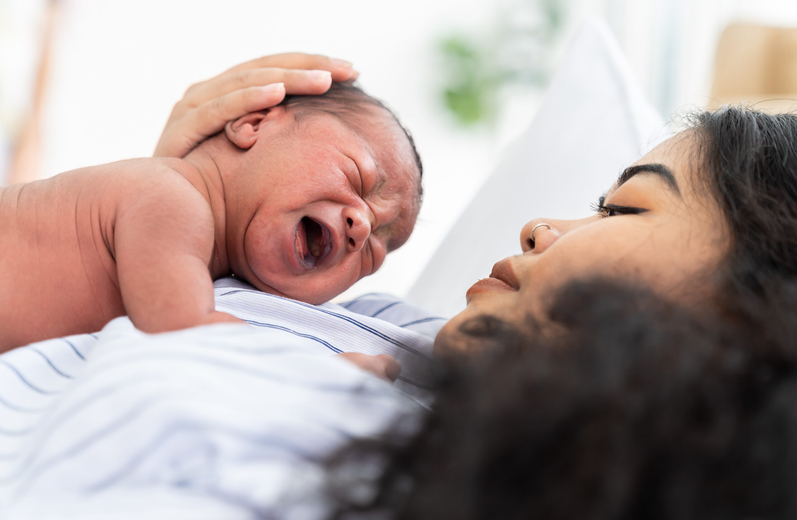 Newborn baby crying on mother's chest