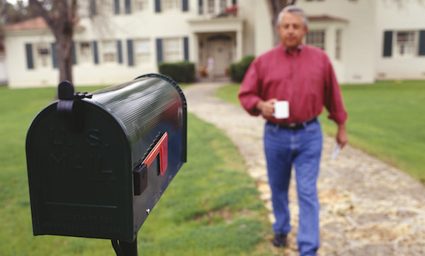 Man walking to mailbox in garden
