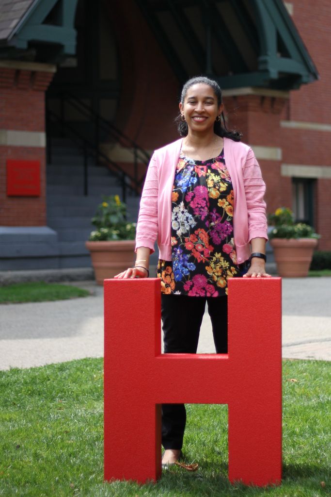 Tenbit Mitiku standing behind a large letter H in front of the Talbot Building
