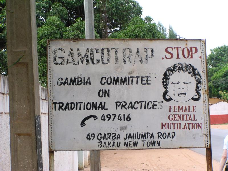 Street sign in Gambia reads "Stop Female Genital Mutilation" from The Gambia Committee on Traditional Practices