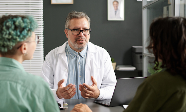 Doctor discussing some questions with lesbian couple during their meeting in office