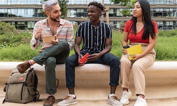 Diverse people having fun eating takeaway-food outdoor in the city. Focus on queer gay man face.